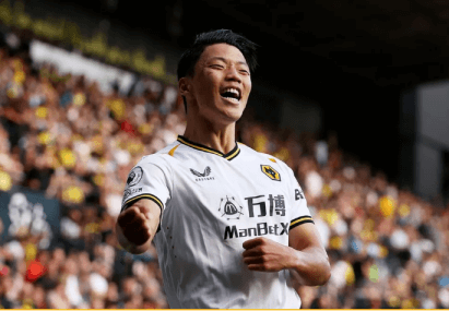 황희찬이 흰색유니폼을 잡고 기뻐하는 모습