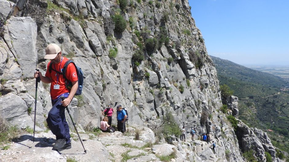 A group of hikers traversing a rugged mountain path during daytime, showcasing adventure.