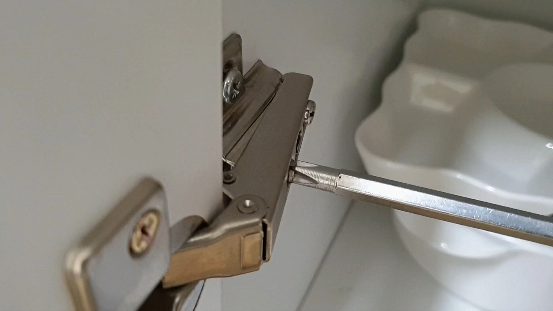 경첩 볼트 조정하는 모습