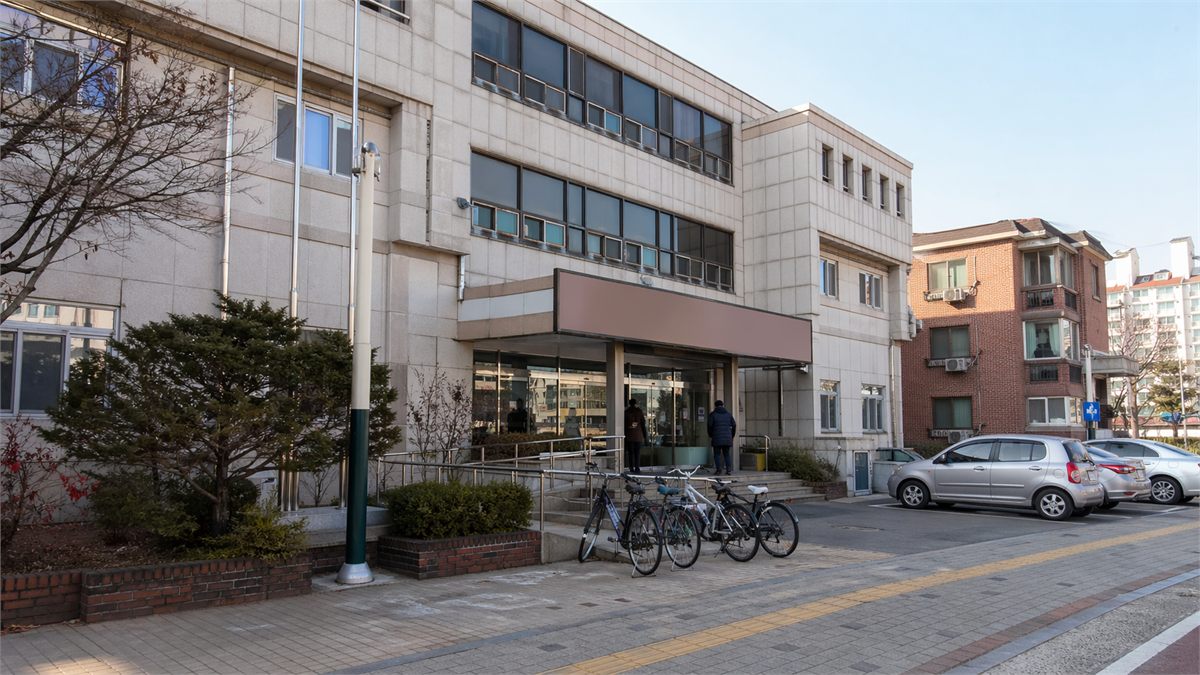 오프라인 신청 장소를 떠올리게 하는 한국 동네 행정복지센터 외관 장면 
