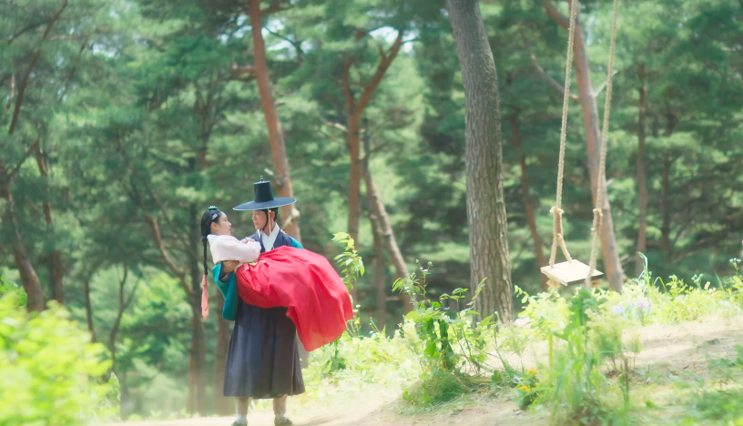 그네에서 떨어지는 여인을 한 사내가 잡아채 안고 있다.