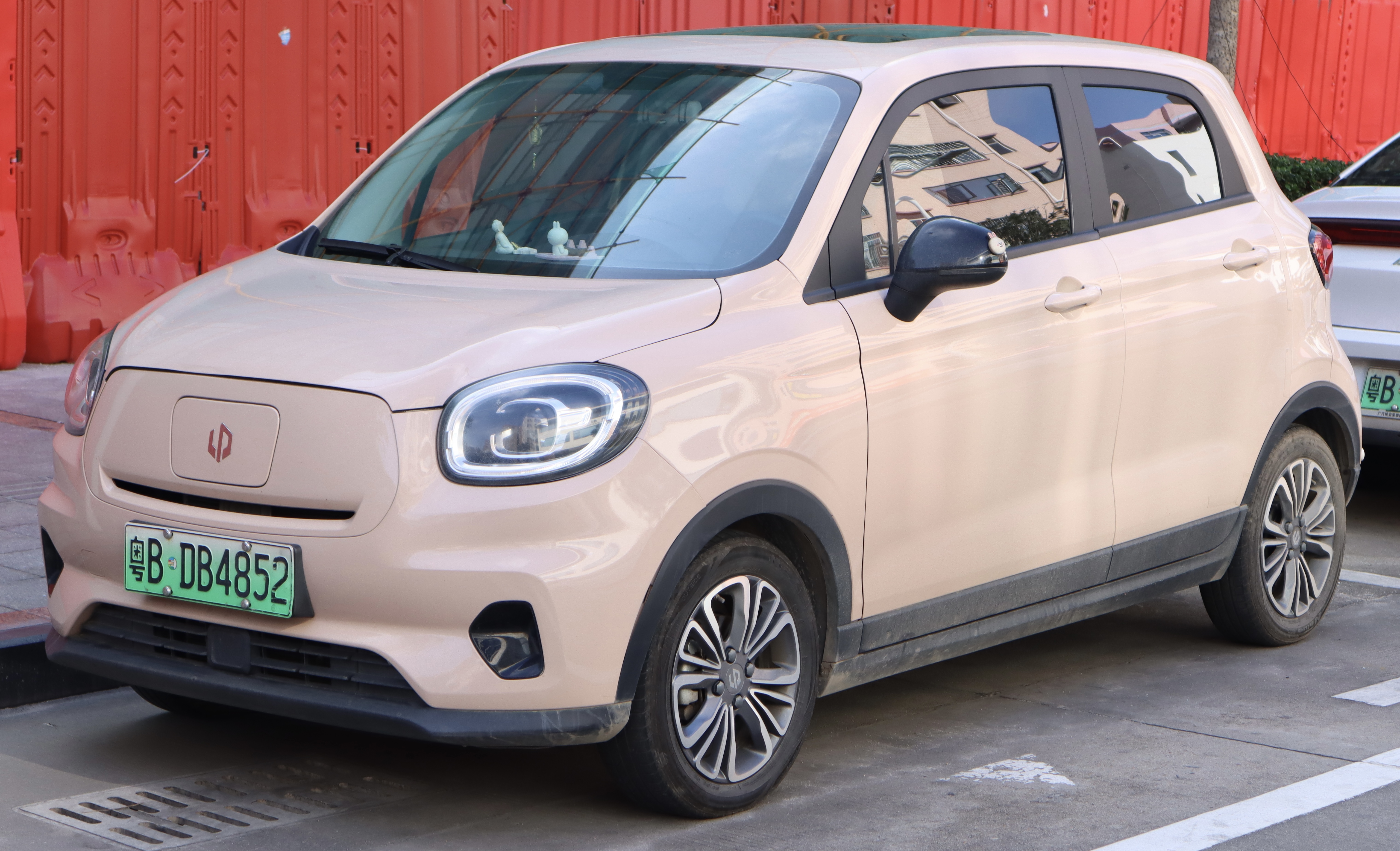 이 사진은 2020년형 리프모터 T03(Leapmotor T03)의 전면 모습입니다. 리프모터 T03은 중국 전기차 제조업체 리프모터에서 생산한 소형 전기차입니다. 사진 속 차량은 베이지 색상이며, 전기차임을 나타내는 특징적인 전면 그릴 디자인과 함께 LED 헤드라이트가 장착되어 있습니다. 차량 앞쪽에 '리프모터'의 로고가 표시되어 있으며, 녹색 번호판을 통해 전기차임을 확인할 수 있습니다. 이 모델은 도시 주행에 적합한 소형 전기차로, 효율성과 친환경성을 강조한 차량입니다.