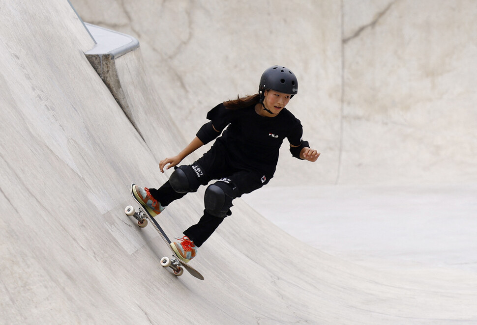 한 여성 스케이트보더가 스케이트보드로 놀라운 묘기를 보여주고 있는 장면입니다.