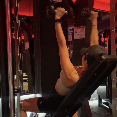 여성 헬스장에서 인클라인 덤벨 프레스 가슴 운동하는 사진