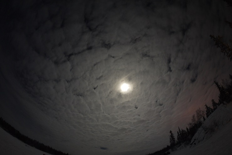 하늘에 보름달이 떠있고, 주변에 구름이 많은 풍경