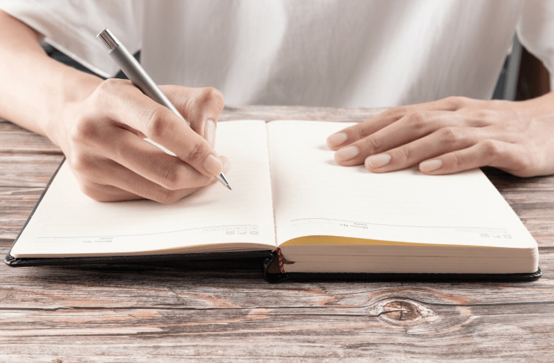 하루 사실 기록 루틴을 위해 노트에 하루를 기록하는 모습