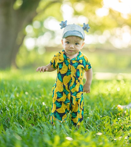 공원 풀숲에 서 있는 아기 사진
