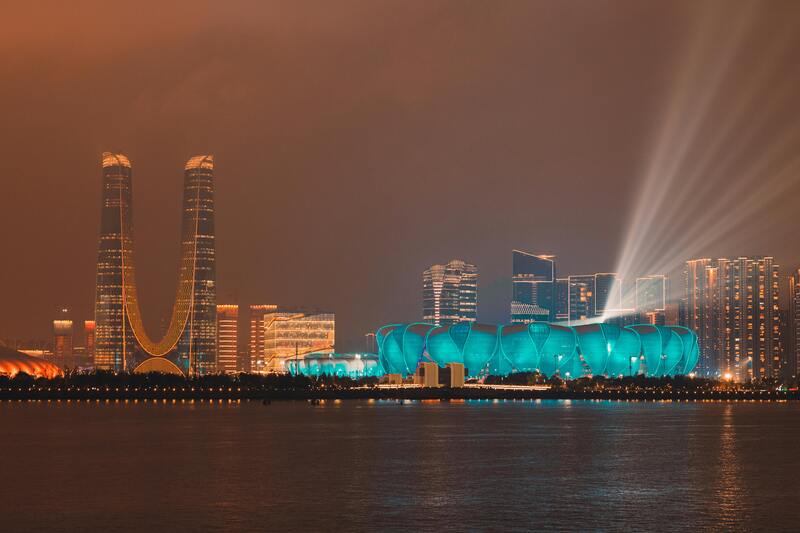 U자형 래플스 시티 빌딩과 항저우 올림픽 스포츠센터가 조명으로 물든 야경 풍경