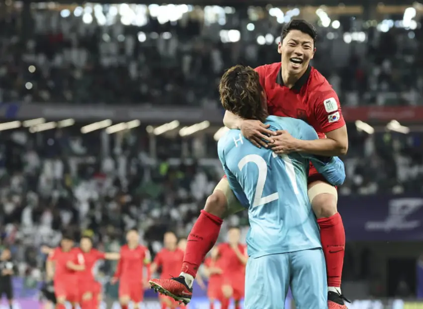 사우디전- 관중이 꽉찬 축구장 파란 유니폼을 입은 조현우에게 빨간유니폼을 입은 황희찬이 매달려 안겨있는 모습