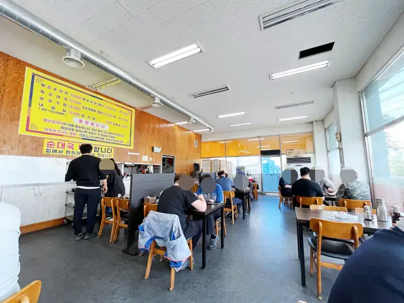 식당 테이블에서 가득찬 모습 사람들이 식사하고 있다