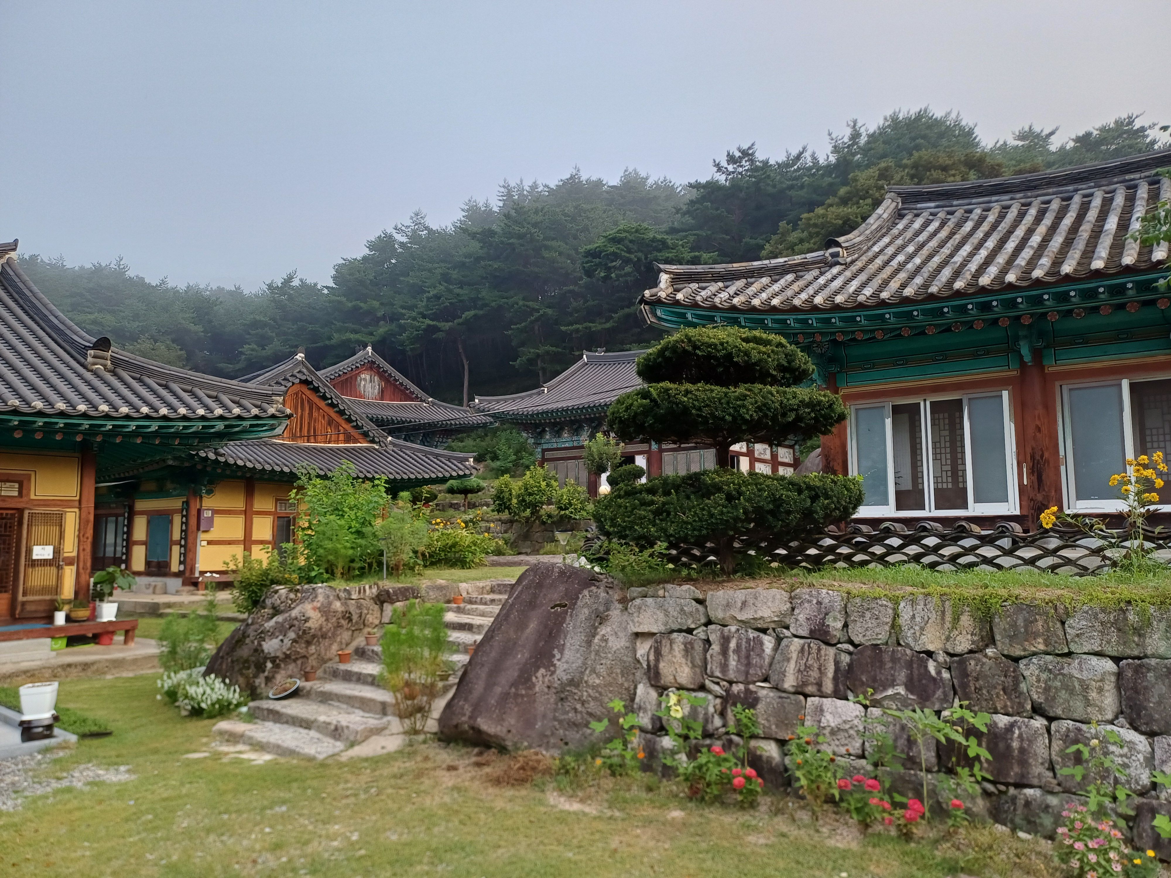 기와지붕이 이어진 전각과 정돈된 화단, 한국 사찰의 단정한 마당