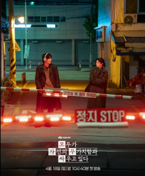 밤의 철도 건널목 앞에 선 두 인물의 드라마 장면