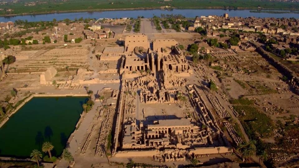 이집트 룩소르에 위치한 카르낙 신전의 아몬 대신전 일대를 담은 항공 촬영 이미지. 좌측에는 신성한 호수가 있고, 중앙에는 기둥 열주와 신전 구조가 정렬되어 있으며, 배경으로 나일강이 흐른다.