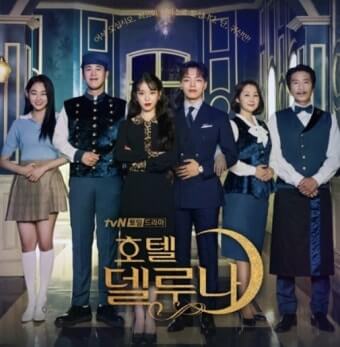 호텔 델루나 출연진들이 호텔 로비에서 두 손을 배에 모은 채 정중하게 앞을 바라보고 있다.