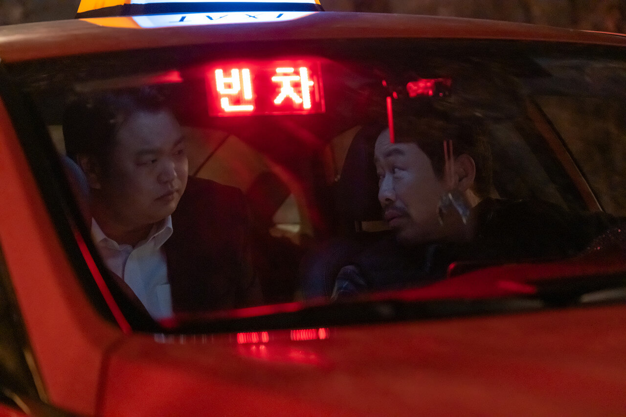 빈차라고 떠 있는 택시 속 경래가 택시기사를 의심스런 눈빛으로 바라보는 모습