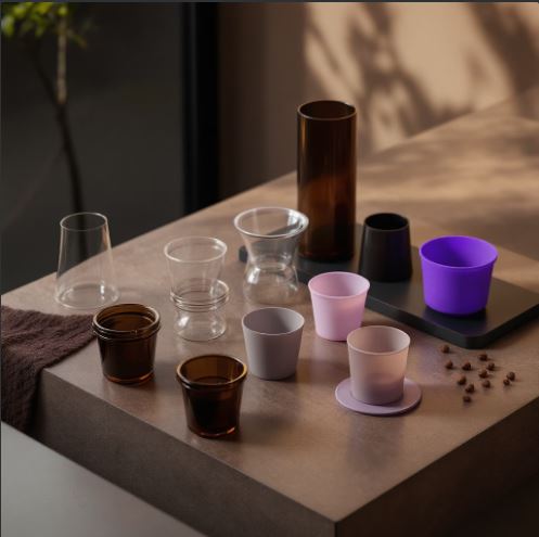 다양한 디자인의 컵들이 테이블에 놓여 있는 모습. 전자식·수동식 부항기, 유리·플라스틱·실리콘 재질 등 부항기 종류의 다양성을 표현한 이미지.