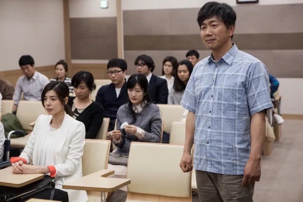 영화 《또 하나의 약속》에서 억울한 진실을 밝히기 위해 용기를 낸 아버지가 증언에 나서는 장면. 평범한 사람들의 작은 외침이 커다란 울림을 만들어낸다.