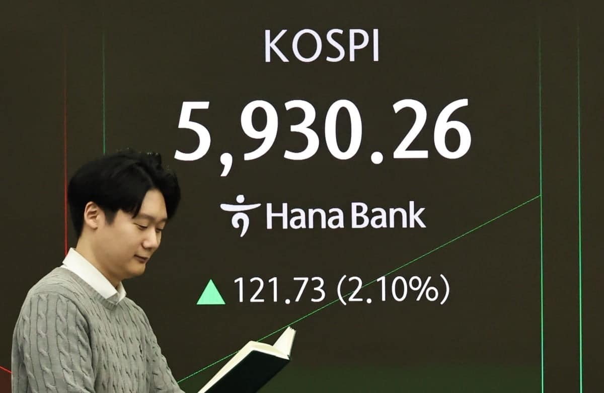 서울 중구 하나은행 딜링룸 전광판 사진. KOSPI 5,930.26, +121.73(+2.10%) 수치가 초록색 상승 그래프와 함께 표시된다. 전광판 앞에 서 있는 직원이 노트를 내려다보고 있다.