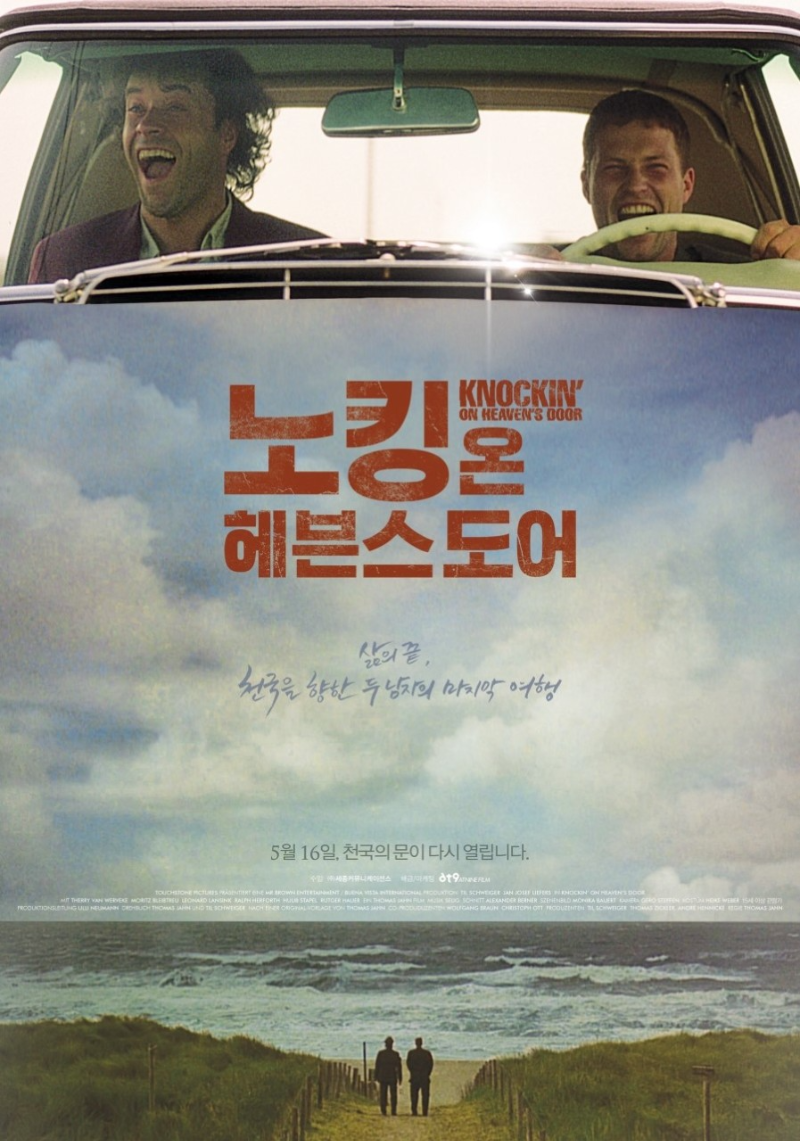 자동차 안에서 두 남성이 활짝 웃으며 바다로 향하는 장면이 상단에 보이며, 하단에는 ‘노킹 온 헤븐스 도어’라는 영화 제목과 함께 “삶의 끝, 천국을 향한 두 남자의 마지막 여행”이라는 문구가 쓰여 있다. 배경에는 흐린 하늘 아래 두 남성이 바다를 향해 걷는 풍경이 펼쳐진다. 개봉일은 5월 16일로 명시되어 있다.