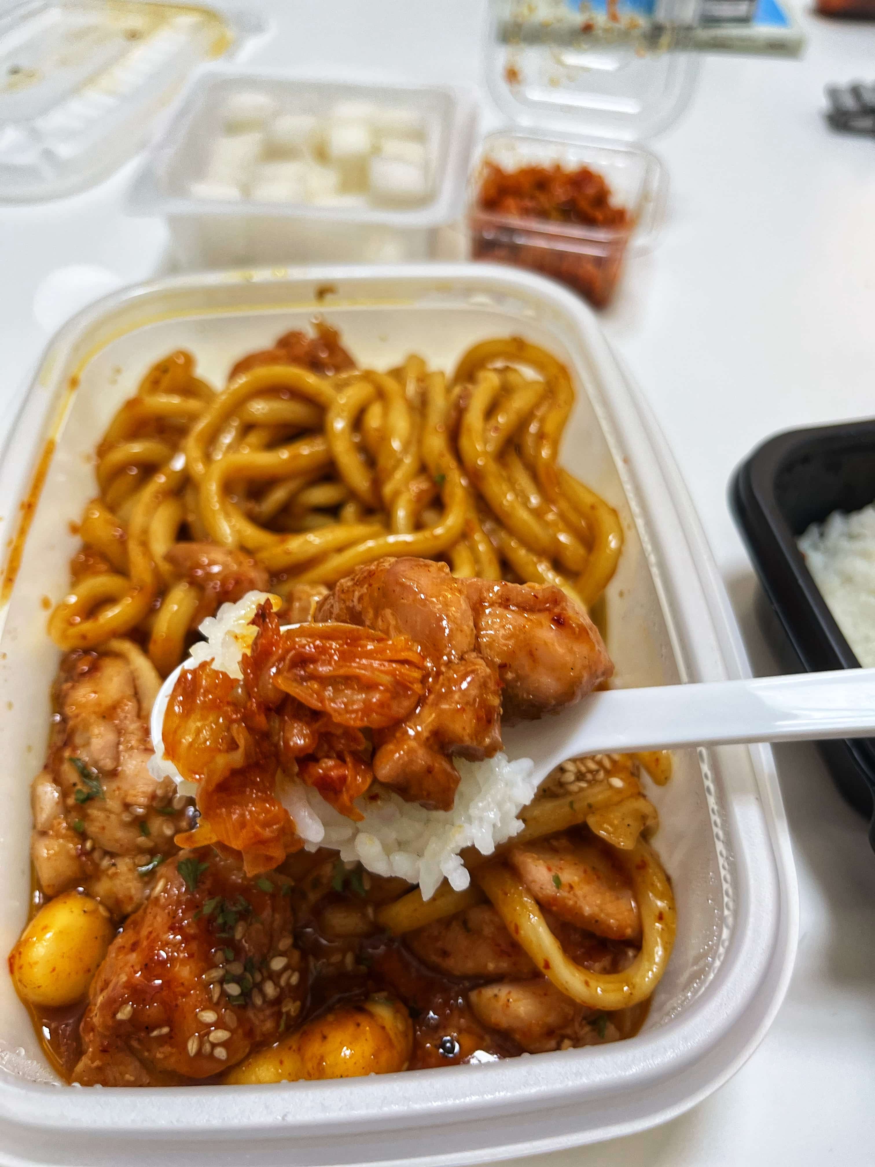 이것은 흰 쌀밥에 숯불양념치킨의 닭다리살과 볶은 김치를 올려먹는 사진입니다.