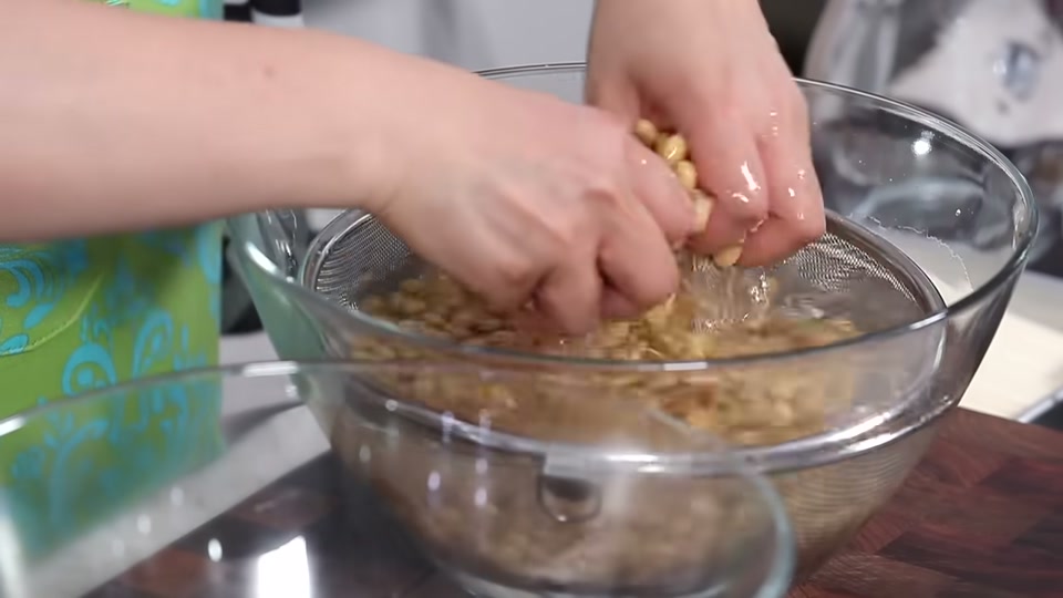 삶은 콩을 손으로 찬물에 헹구는 장면