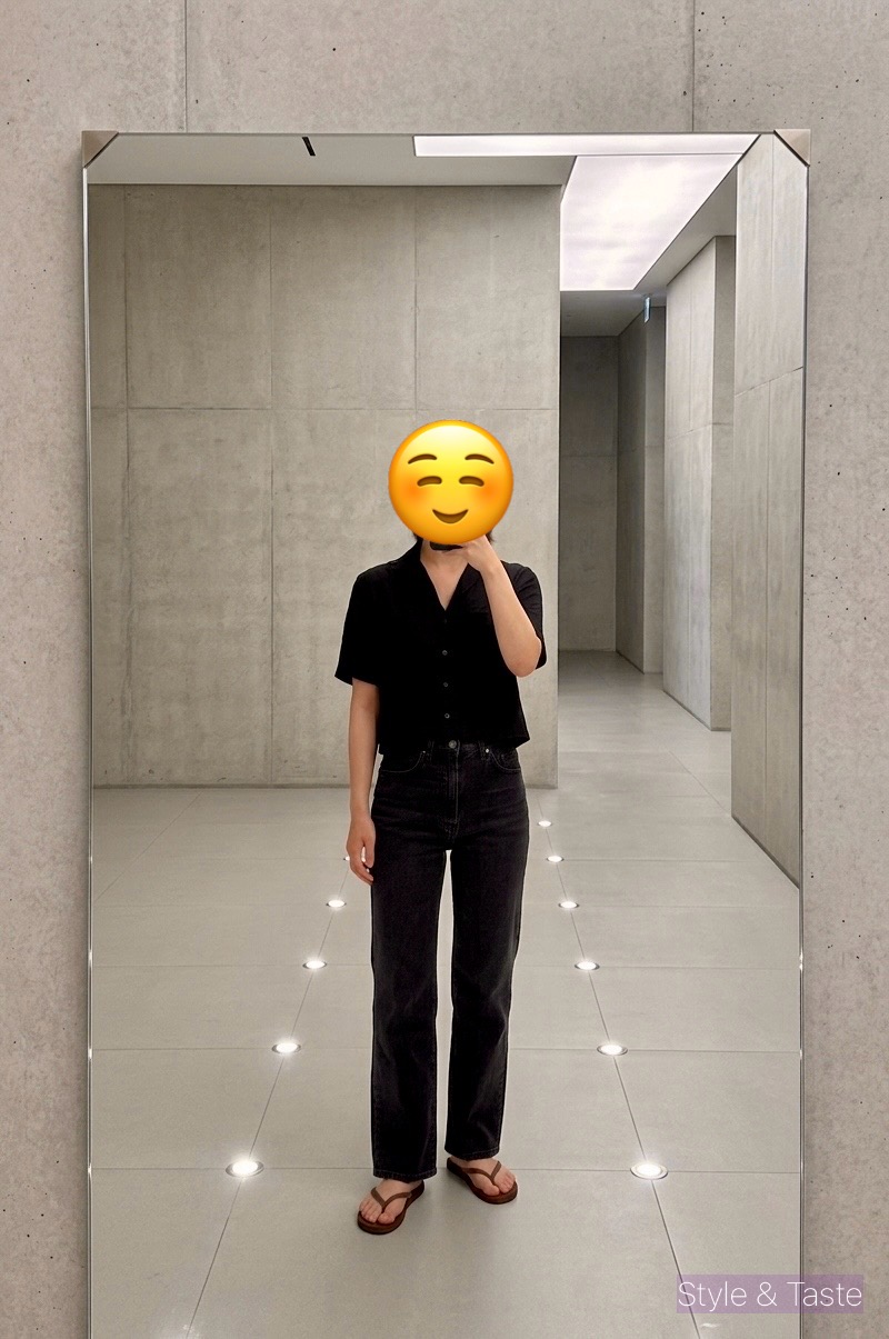 이모티콘으로 얼굴을 가리고, 거울에 비친 자신의 모습을 촬영하는 전신 샷. 검은색 반팔 셔츠와 바지, 갈색 아치스 쪼리를 착용하고 있음