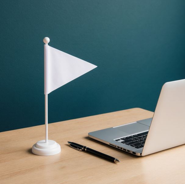 노트북과 펜이 있는 깔끔하게 정리된 책상. 깃발을 책상 위에 놓아두어 셀프 플랜의 이미지를 강조한 사진이다.
