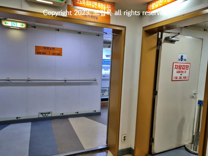 퀸메리호 내부의 갑판, 이코노미,화장실등이 표시된 안내표와 복도와 방화문