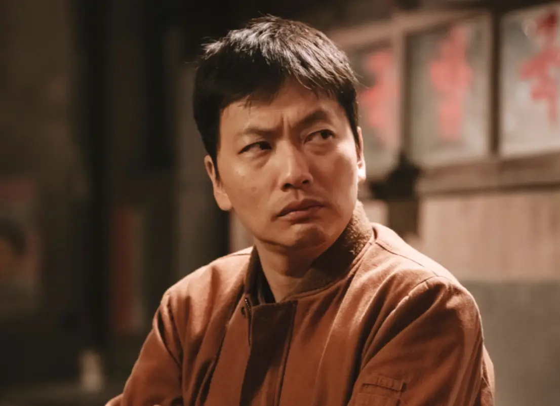 수사반장-술집에 앉아 갈색 세무점퍼를 입고 옆을 진지하게 바라보는 이동휘