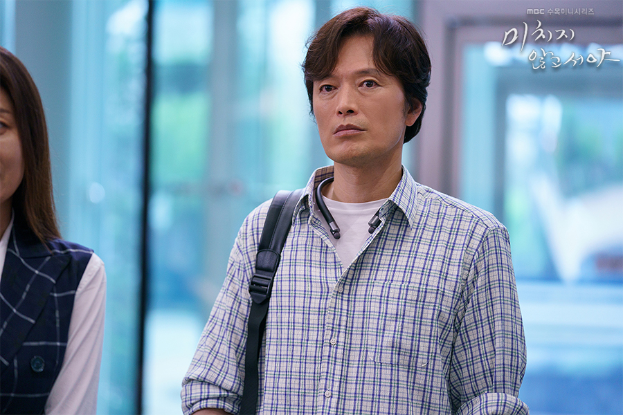 어깨에 가방을 메고 회사 안에 서 있는 최반석 역 정재영