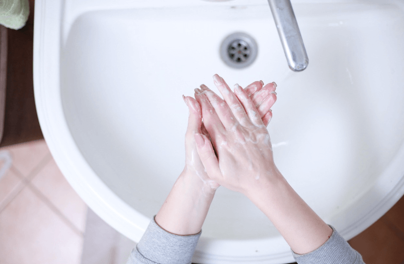 세면대에서 손씻기 하는 여성