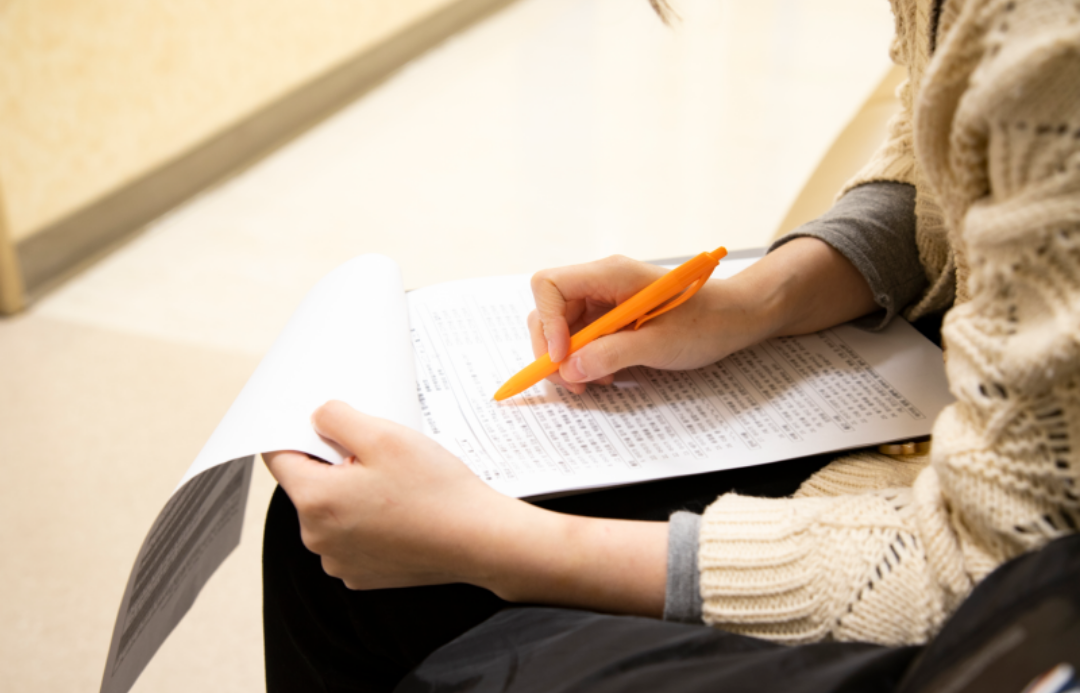 대학생이 앉아서 서류를 보고 있다.