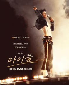 마이클잭슨이마이크를들고서있다.