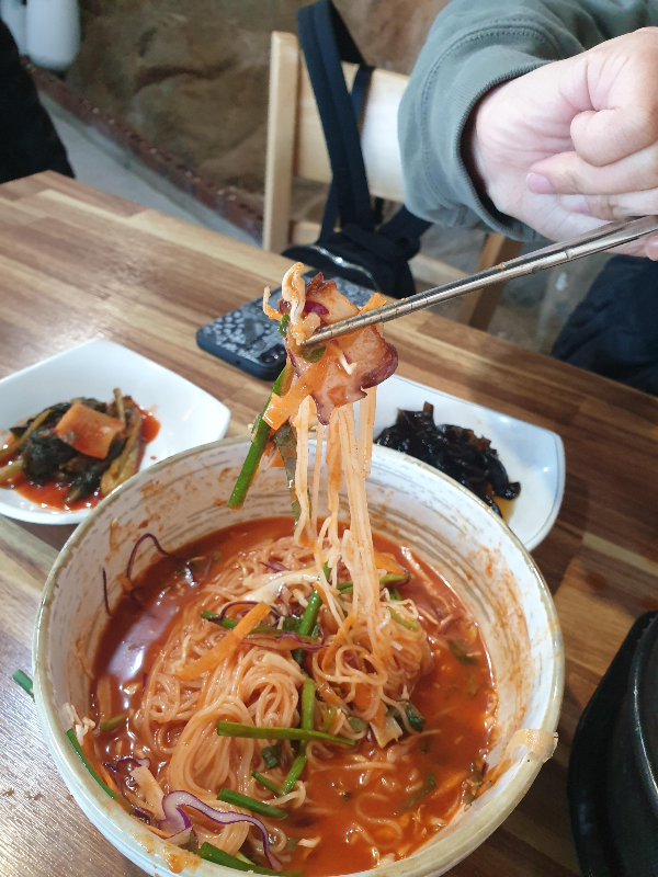 젓가락으로 국수와 문어를 함께 집어 든 모습