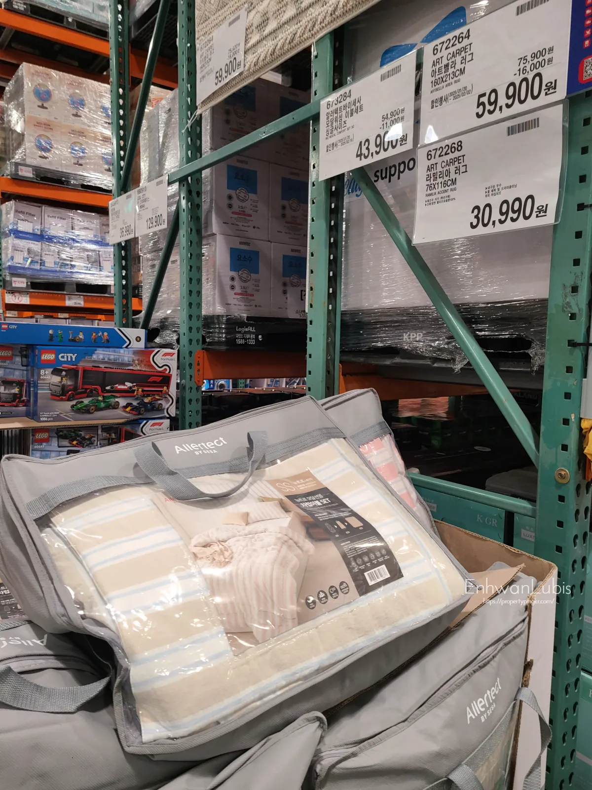 초록색-메탈-선반에-가격표가-있고-베이지색-줄무늬-이불이-단긴-이불가방이-있다.