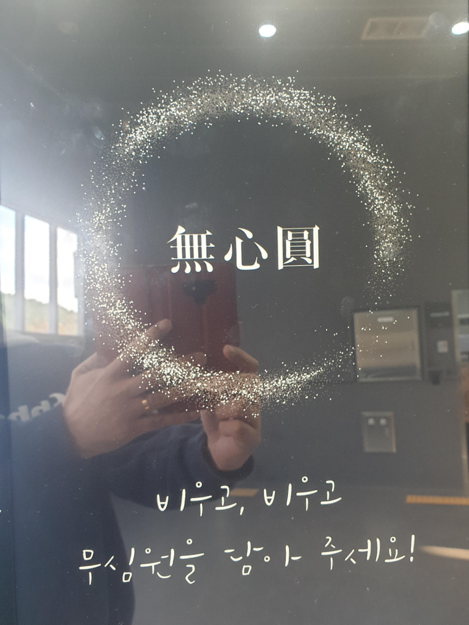무심원이라는 한자 주위에 점으로 이뤄진 원.