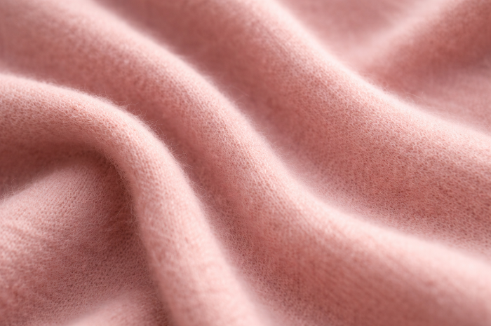 고급 캐시미어 소재와 결합된 더스티 핑크의 정교한 텍스처 클로즈업.