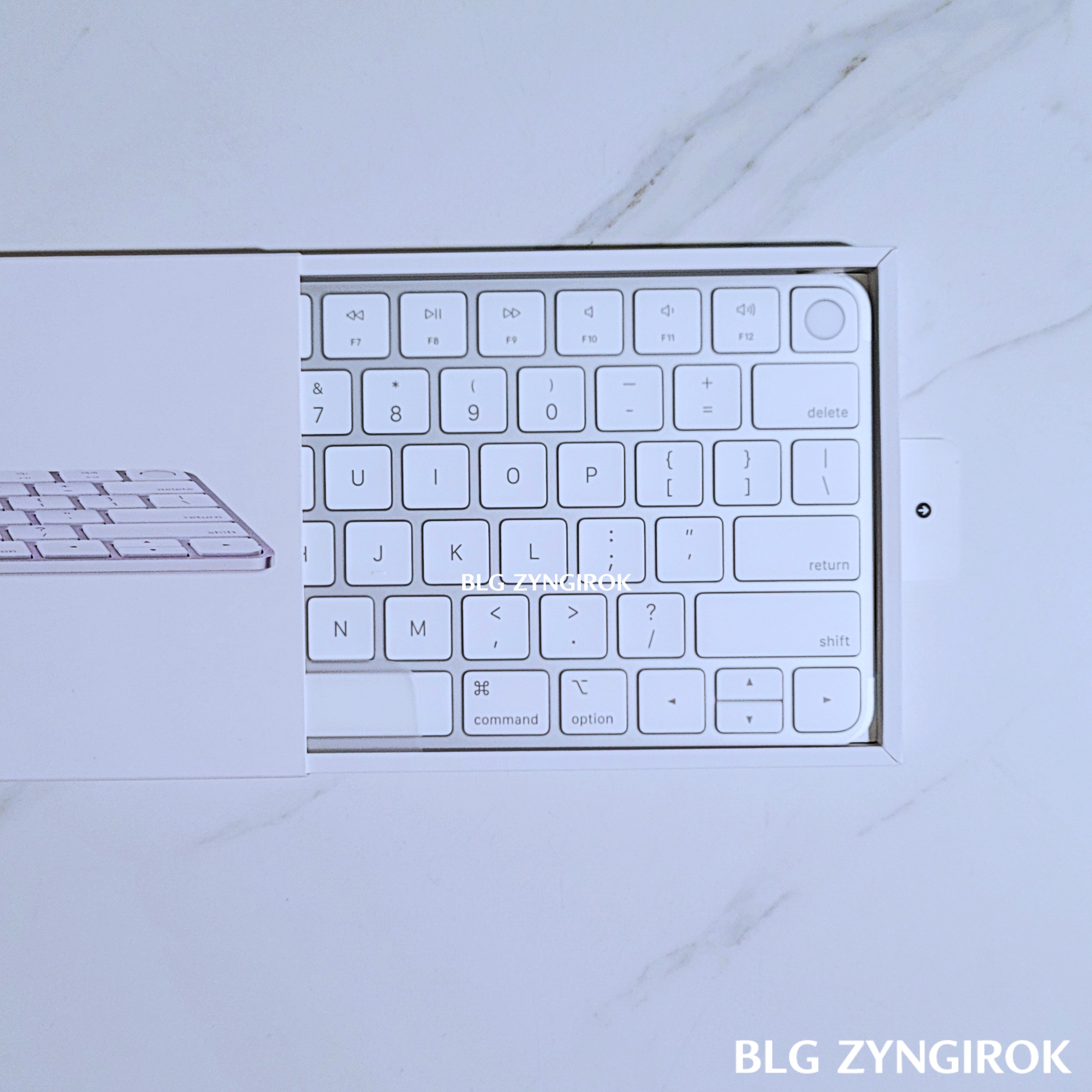 상자에서 매직키보드를 꺼내고 있다.