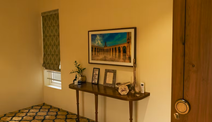 봄 인테리어 소품을 활용해 콘솔 테이블 위에 액자와 화분을 배치한 집 인테리어 예시