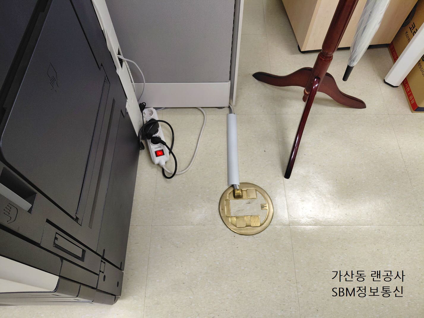 사무실 대형 복합기와 멀티탭으로 안전하게 연결된 바닥 몰딩 및 랜선