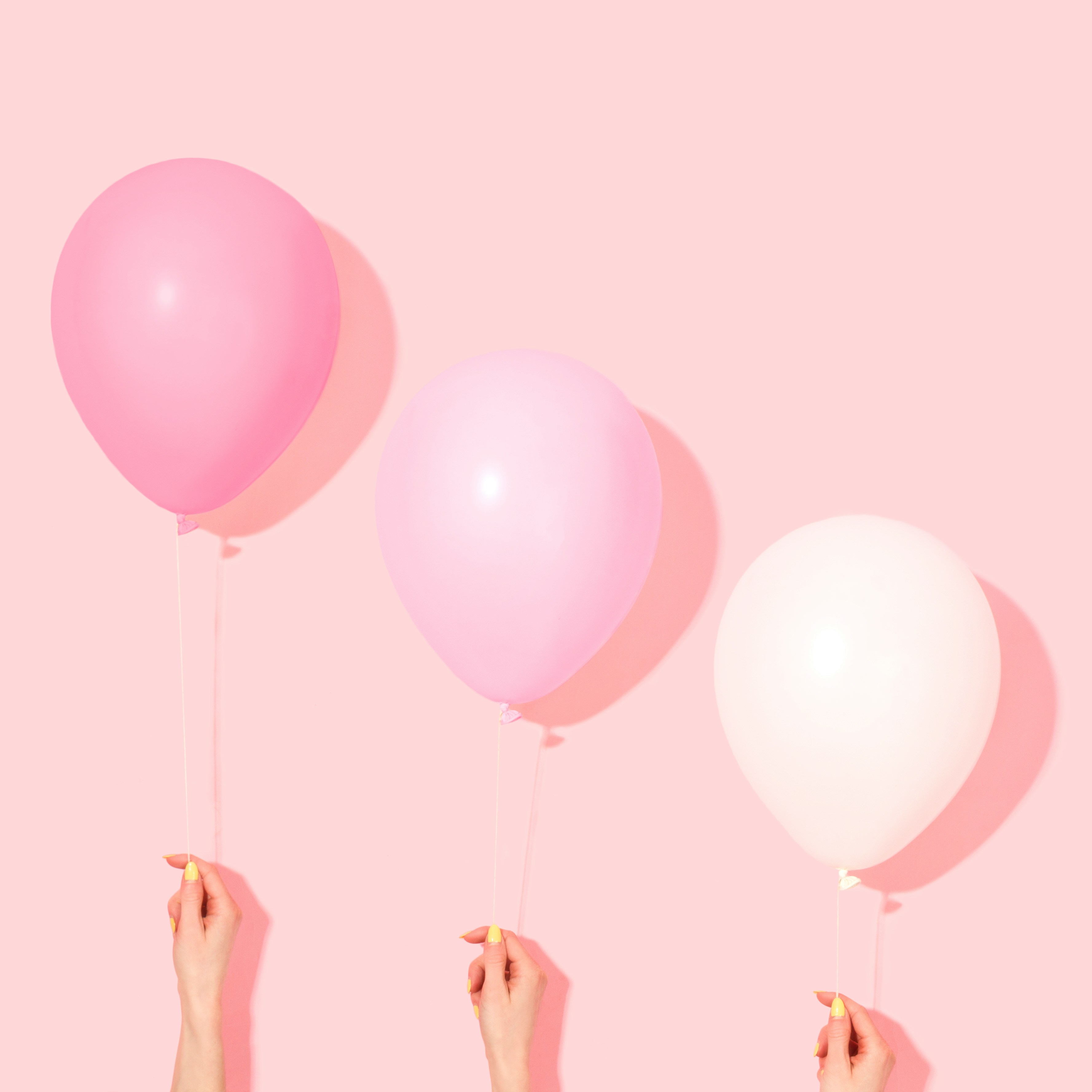 세 개의 분홍색 풍선을 들고 있는 손 – 영어 원서 읽기(N회독) 전략 상징 이미지