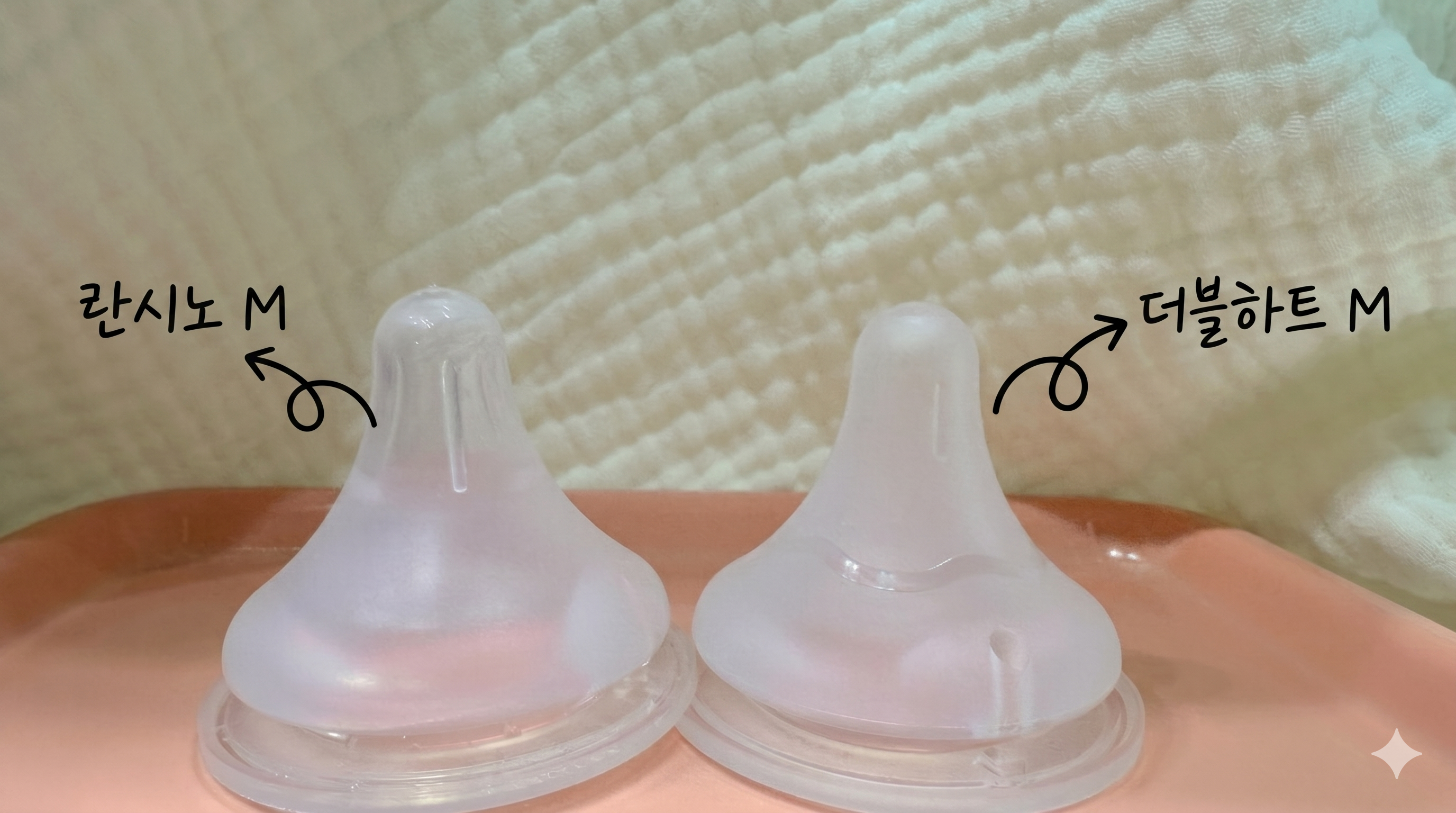 분홍색 쟁반 위에 란시노 M과 더블하트 M 젖꼭지를 단독으로 두고 손글씨와 돼지꼬리 표기로 브랜드를 명확히 구분한 상세 비교 사진