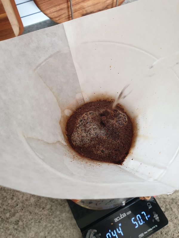 물을 머금은 커피 원두에 물을 푸어하는 모습(서클 푸어)