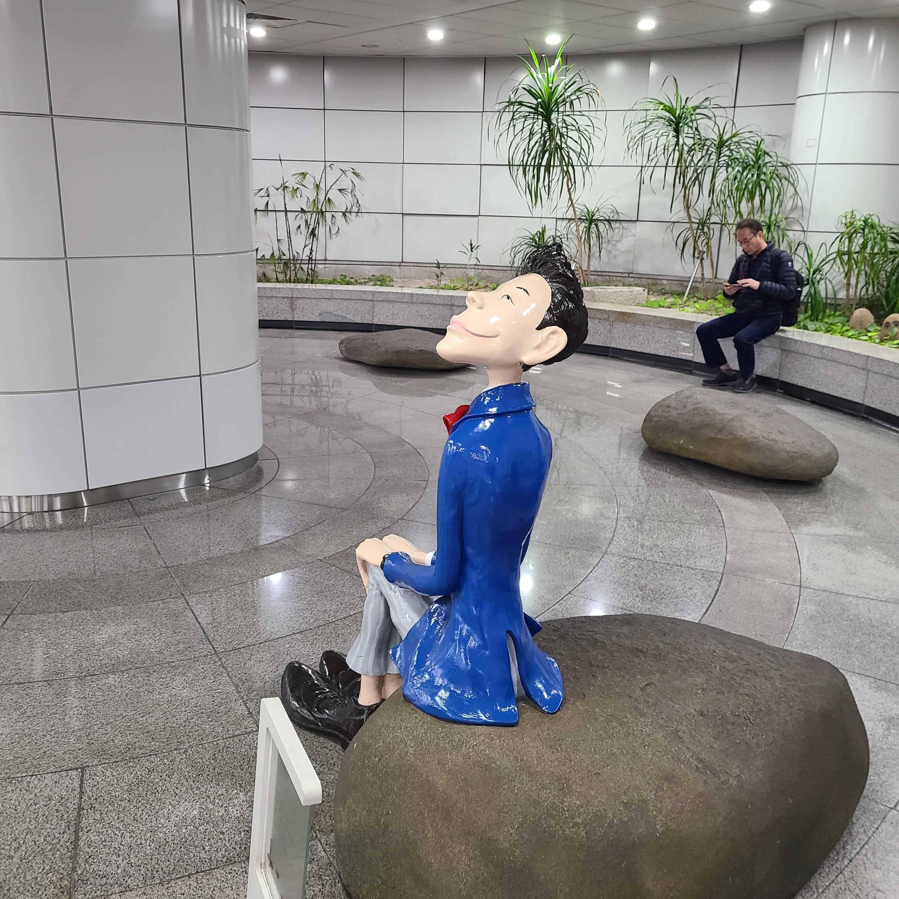 바위 위에 앉아 있는 파란 양복 신사와 분홍 원피스 여인 조형물 사진들