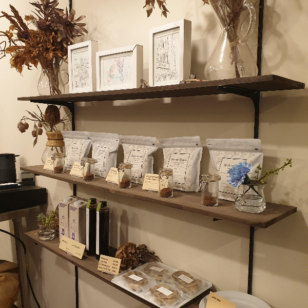 선반에 판매용 원두가 진열 되어 있다. 시향을 위해 작은 컵에 분쇄된 원두가 담겨 있다.