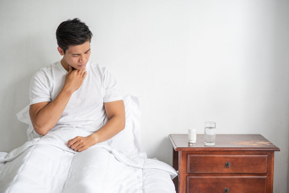 아침에 목을 만지고 있는 남자