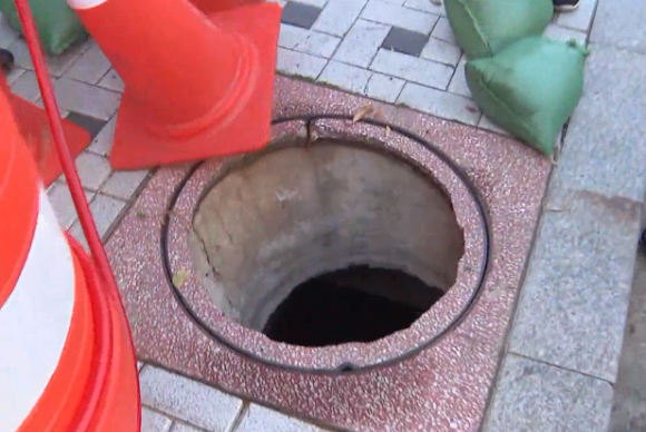 부산의 인도에 있던 한 맨홀 뚜껑이 갑자기 부서지면서 길을 걷던 행인이 부상을 입었다. [사진=SBS 보도화면 캡처]