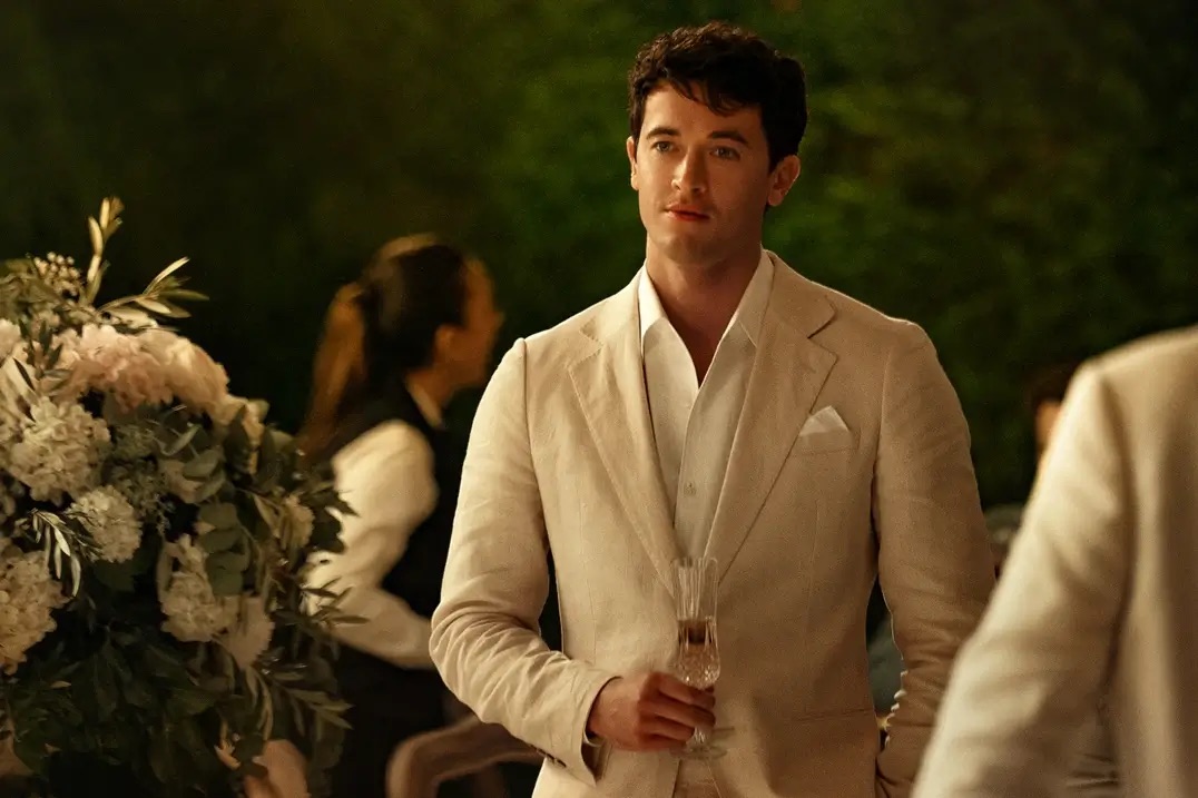 하얀 정장을 입고 샴페인 잔을 든 알렉스