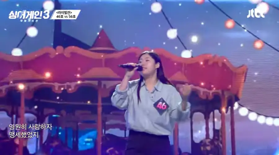 싱어게인3-
회전목마 무대배경 파란 줄무늬셔츠 검은 마이크를 들고 긴머리를 풀어헤친채 심사위원을 보고 노래하는 46호