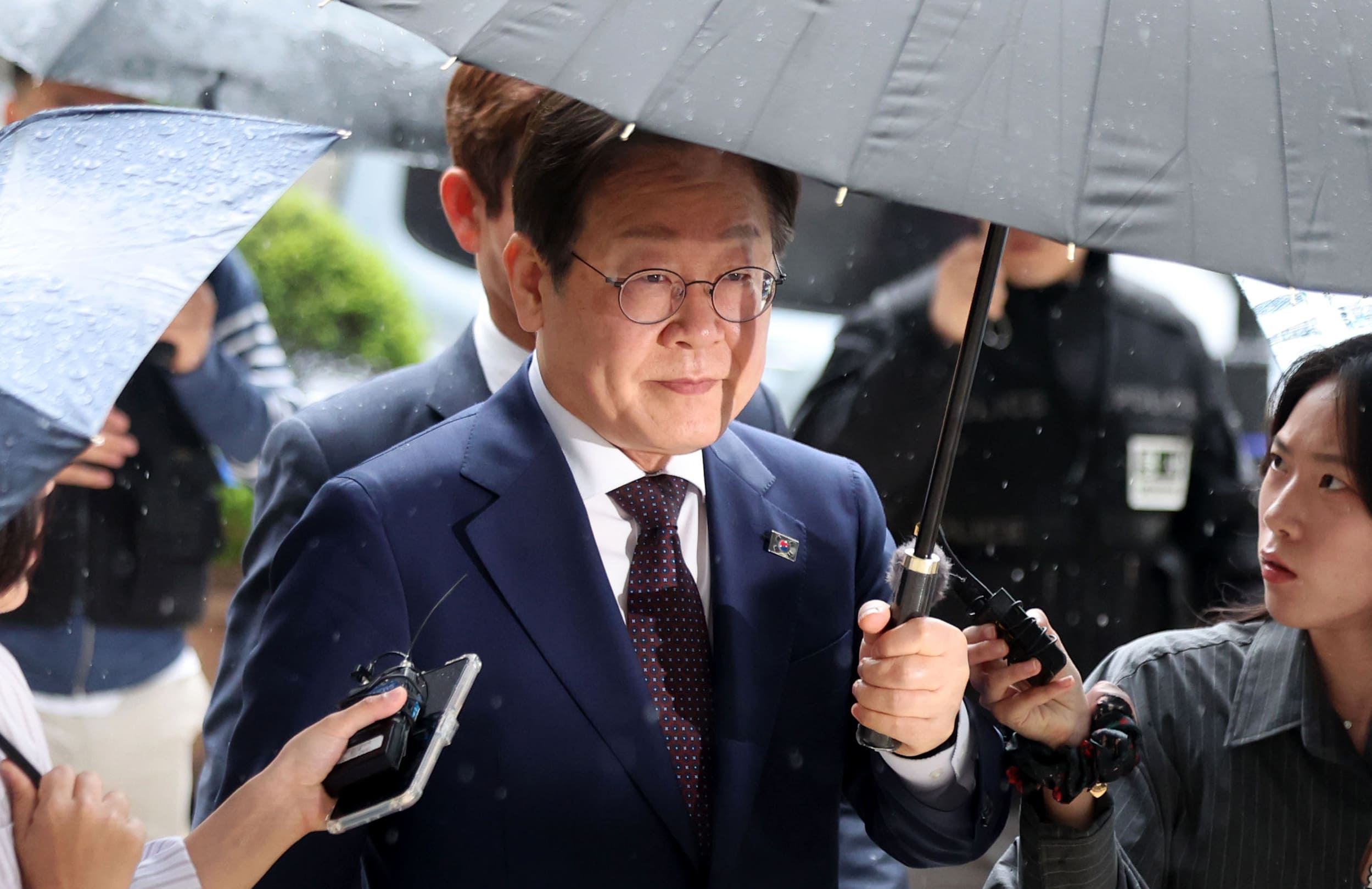 우산을 쓴 채 공판에 출석하는 이재명
